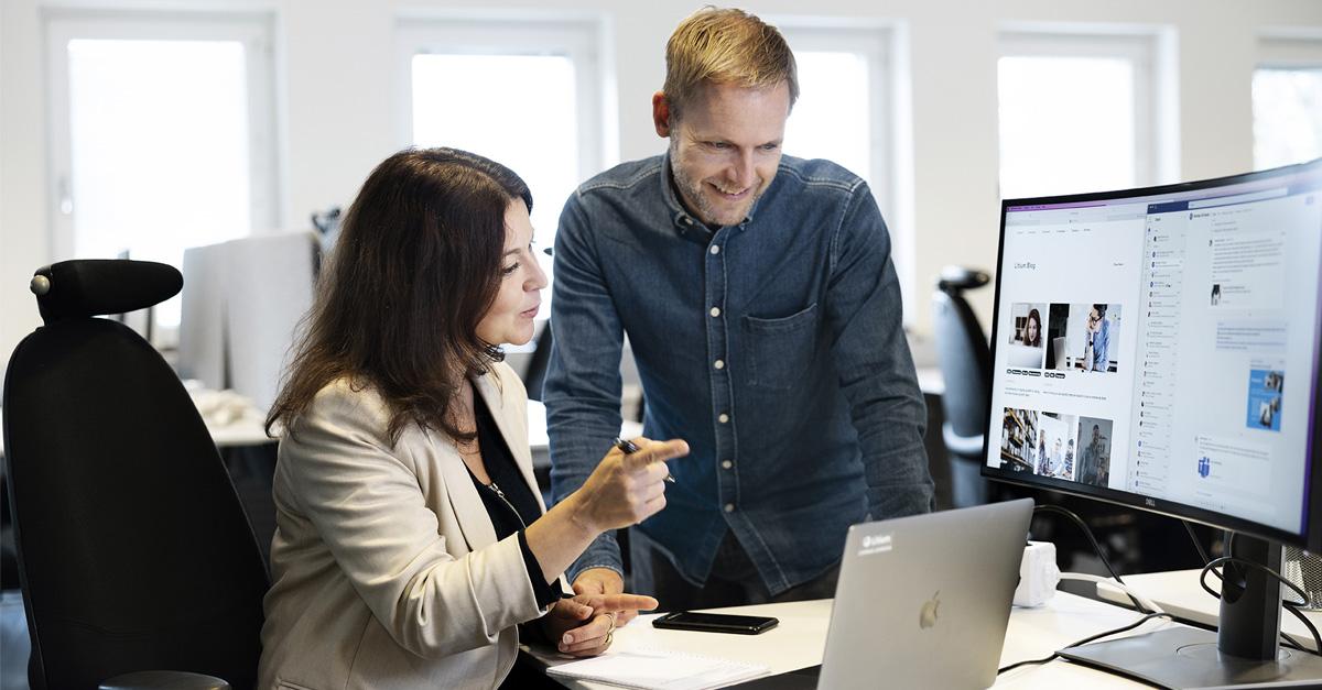 Two people looking at a computer screen. 