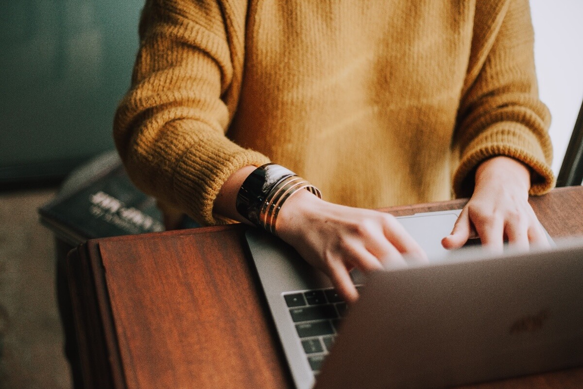 girl in yellow sweater in front of computer