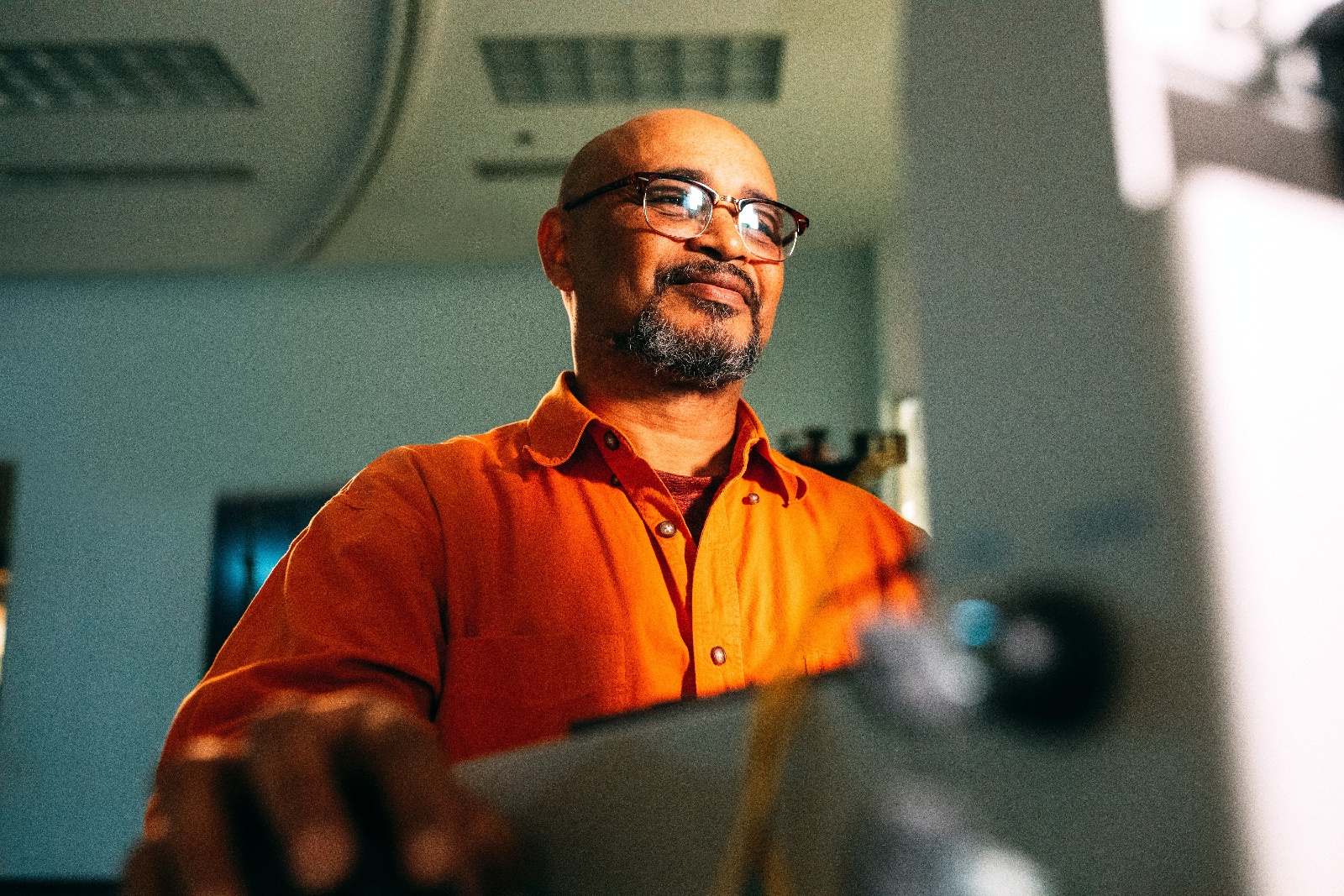 guy in orange shirt in front of computer